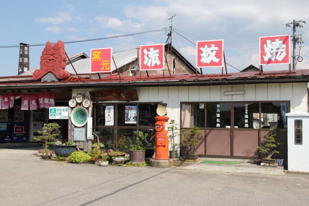 赤ポストやシーサーの看板が並ぶ窯元流紋焼の外観