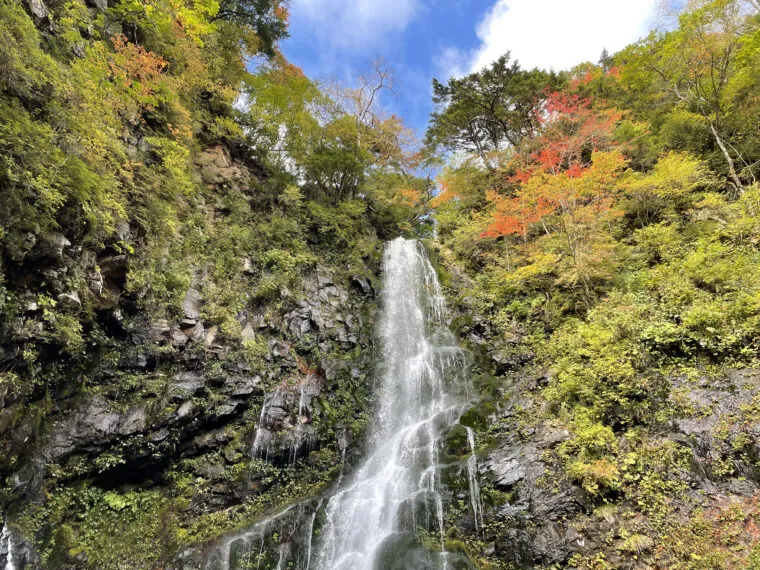 A Waterfall Cascading Through a Mountain Painted in Autumn Colors