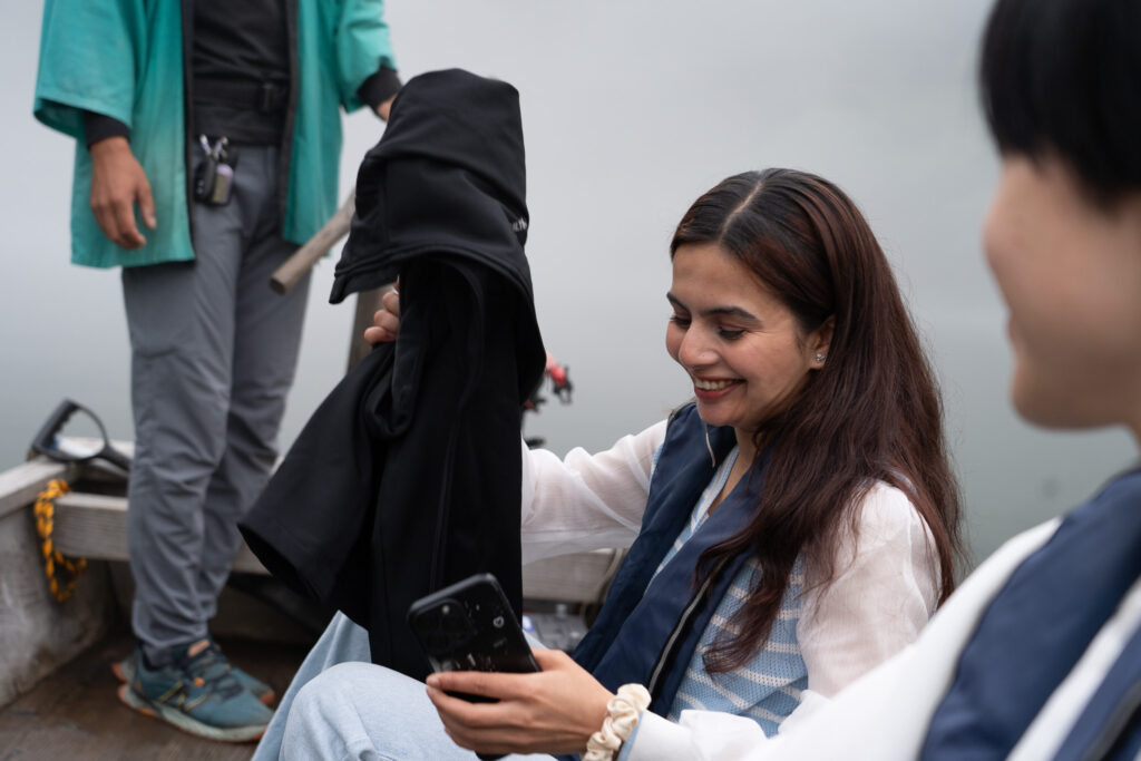 観光客の1人が舟漕ぎに挑戦しようと立ちあがろうとしている様子。