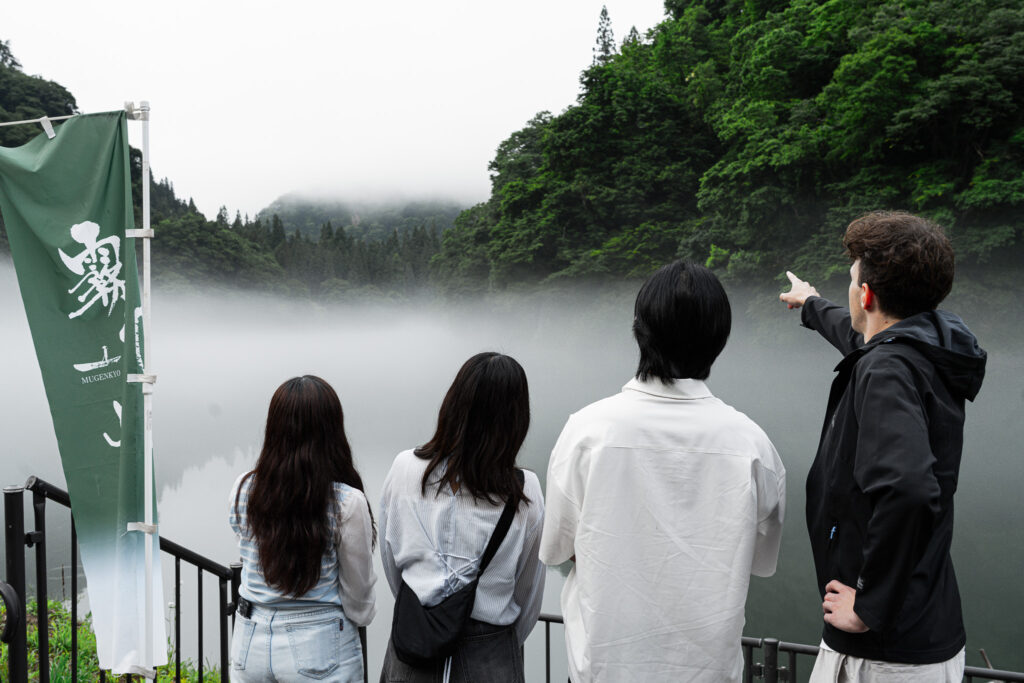 朝霧に包まれた只見川と深緑の山々が織りなす絶景を、仲間と共に楽しむ様子。