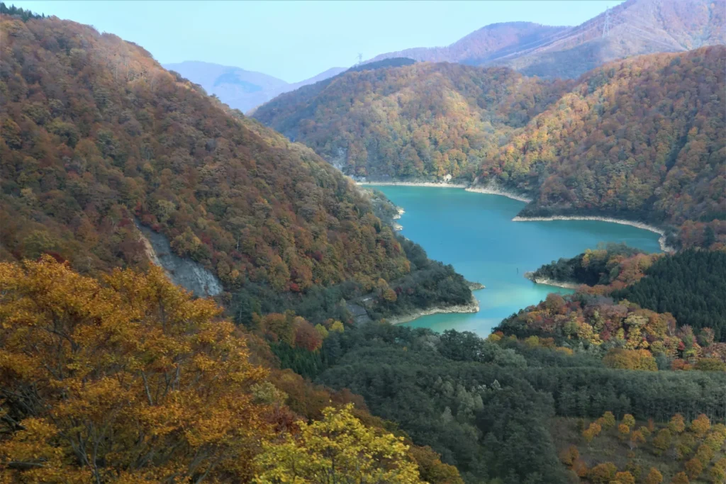苗場スキー場付近の紅葉に染まった高山と中央の湖