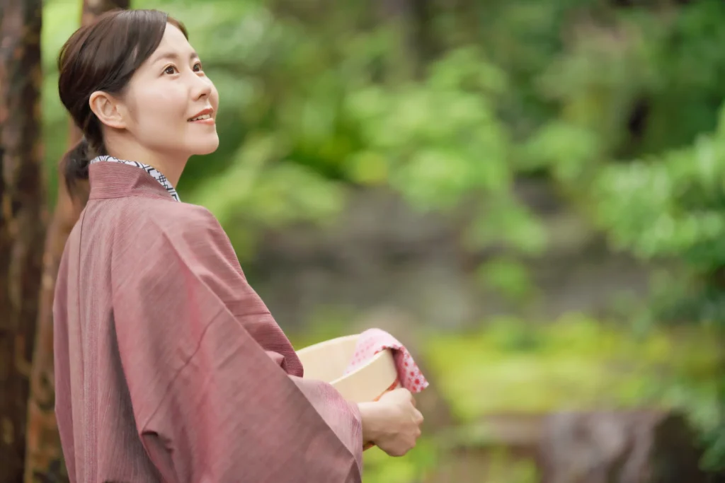 旅館着を着て外を見渡す女性