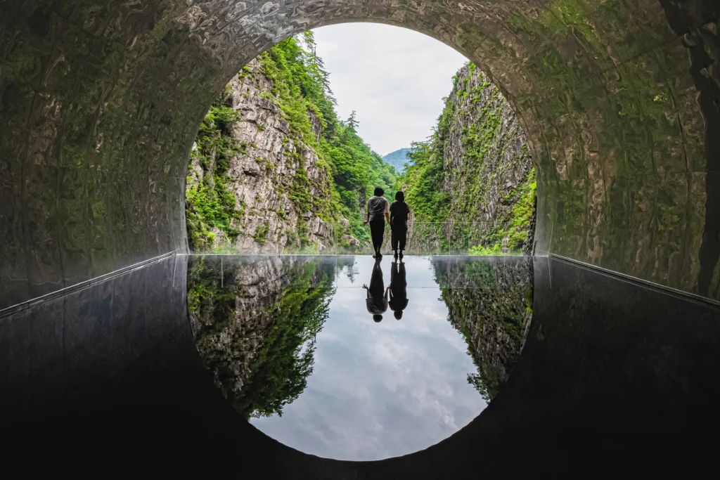 清津峡渓谷トンネルの中から絶景を眺めている男女