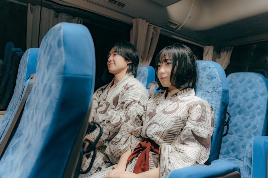 浴衣姿でバスに乗っている男女